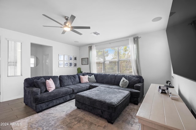 living area featuring baseboards, wood finished floors, visible vents, and a ceiling fan