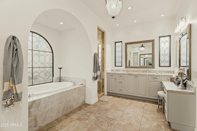 bathroom with a shower stall, a garden tub, recessed lighting, and vanity