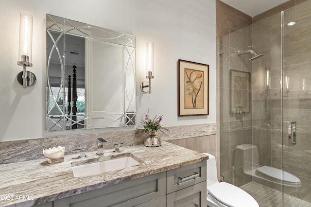 full bath featuring toilet, a shower stall, and vanity