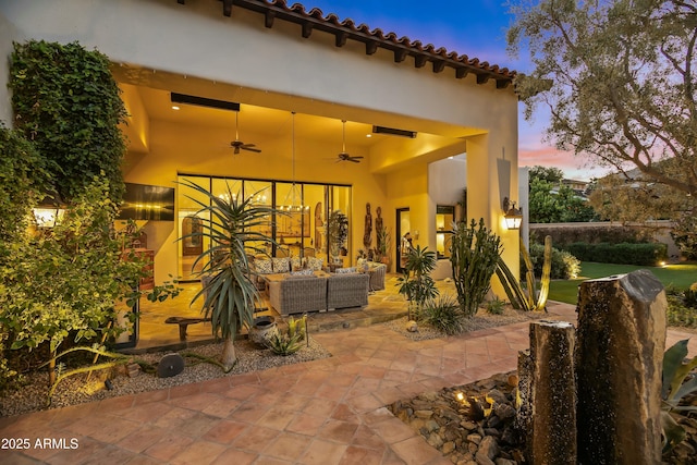 patio terrace at dusk featuring ceiling fan and outdoor lounge area