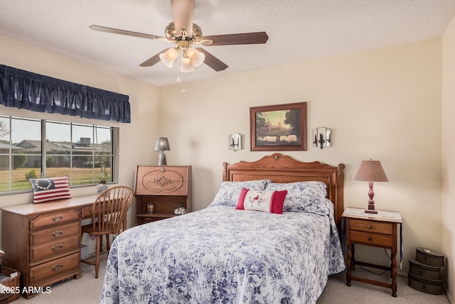 bedroom featuring ceiling fan, light colored carpet, and a textured ceiling