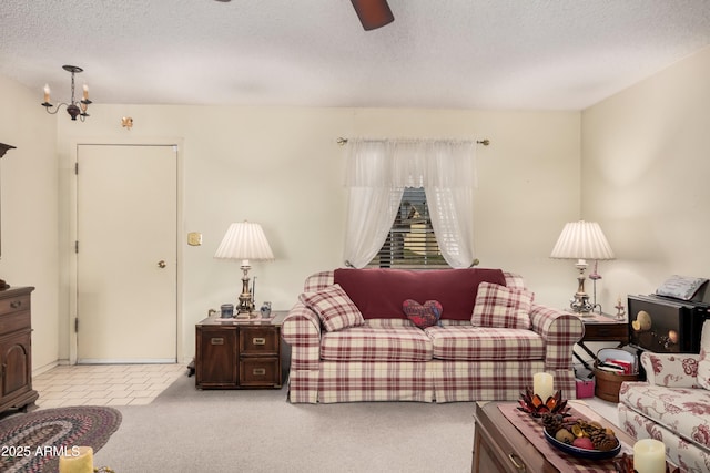 living room with ceiling fan, light colored carpet, and a textured ceiling