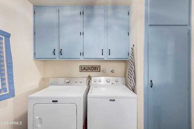 clothes washing area featuring cabinets and separate washer and dryer