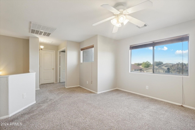 carpeted spare room with ceiling fan