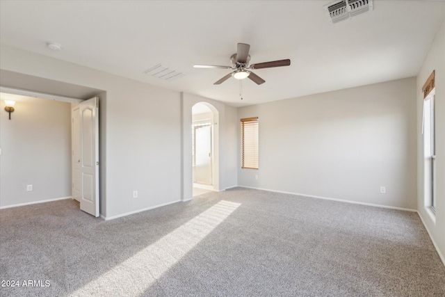 unfurnished bedroom featuring ceiling fan, ensuite bathroom, and light carpet