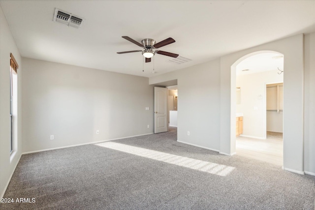 carpeted spare room featuring ceiling fan