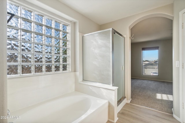 bathroom featuring wood-type flooring and independent shower and bath