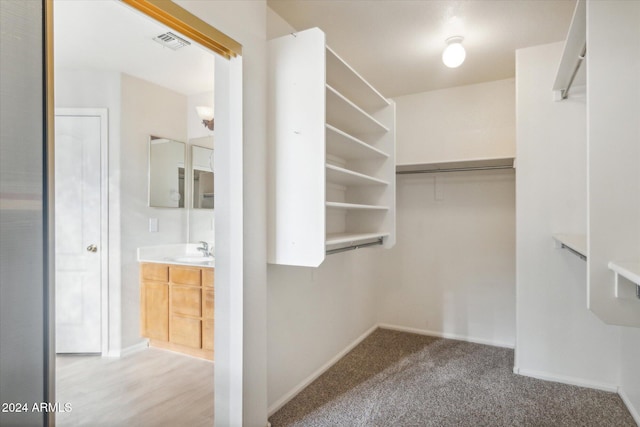 walk in closet with light hardwood / wood-style flooring and sink