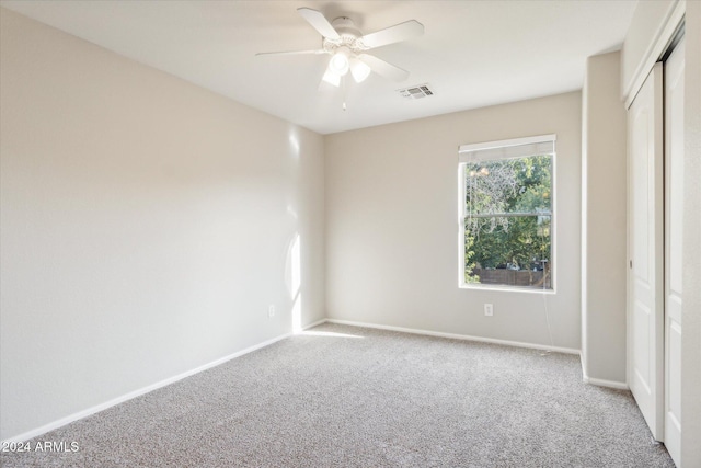 unfurnished bedroom featuring carpet flooring, ceiling fan, and a closet