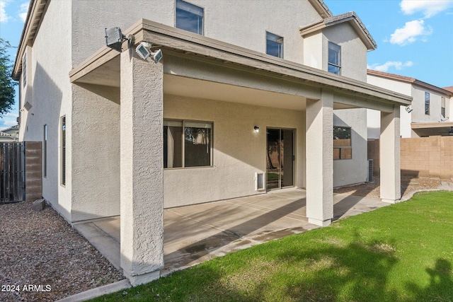 back of property featuring a yard and a patio area