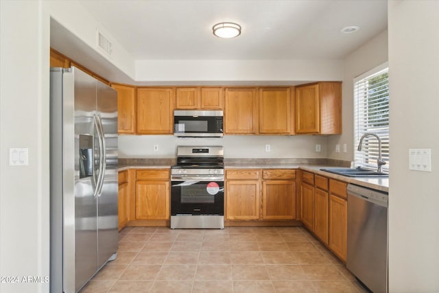 kitchen featuring light tile patterned flooring, appliances with stainless steel finishes, and sink