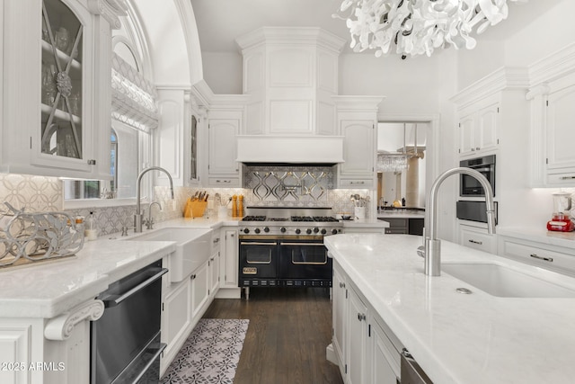 7475 E Gainey Ranch Rd Unit 22, Scottsdale, AZ 85258 - kitchen with stainless steel dishwasher, range with two ovens, white cabinetry, a chandelier, and light countertops