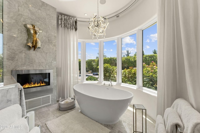7475 E Gainey Ranch Rd Unit 22, Scottsdale, AZ 85258 - full bath with a freestanding tub, a chandelier, plenty of natural light, and a fireplace