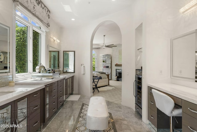 7475 E Gainey Ranch Rd Unit 22, Scottsdale, AZ 85258 - bathroom featuring a fireplace, ceiling fan, vanity, recessed lighting, and wine cooler