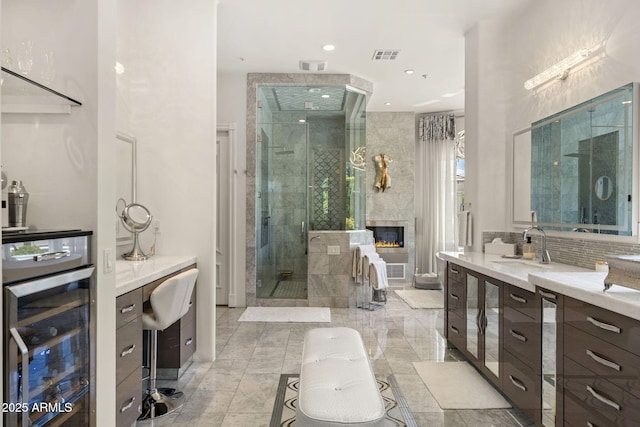 7475 E Gainey Ranch Rd Unit 22, Scottsdale, AZ 85258 - full bathroom with beverage cooler, a shower stall, vanity, a fireplace, and recessed lighting