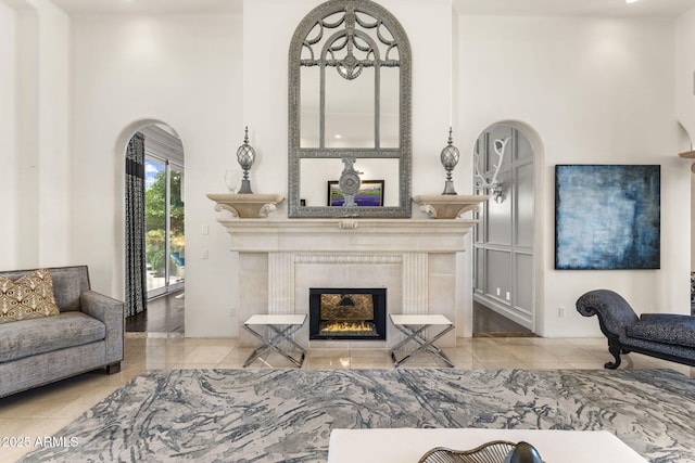 7475 E Gainey Ranch Rd Unit 22, Scottsdale, AZ 85258 - living area featuring tile patterned flooring, arched walkways, and a tiled fireplace