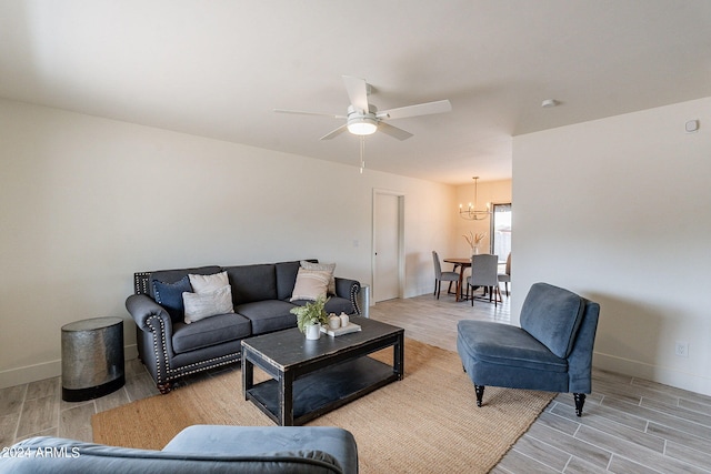 living room with ceiling fan with notable chandelier