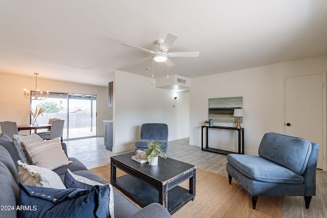 living room featuring ceiling fan with notable chandelier