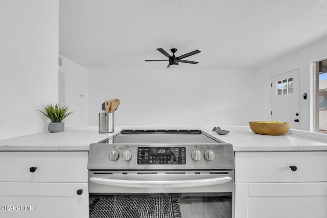 kitchen with light stone countertops, sink, white cabinets, and stainless steel refrigerator