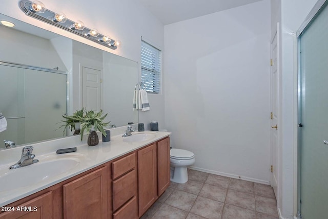 bathroom with tile patterned floors, toilet, vanity, and walk in shower