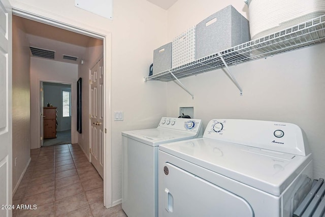 laundry area featuring light tile patterned floors and separate washer and dryer