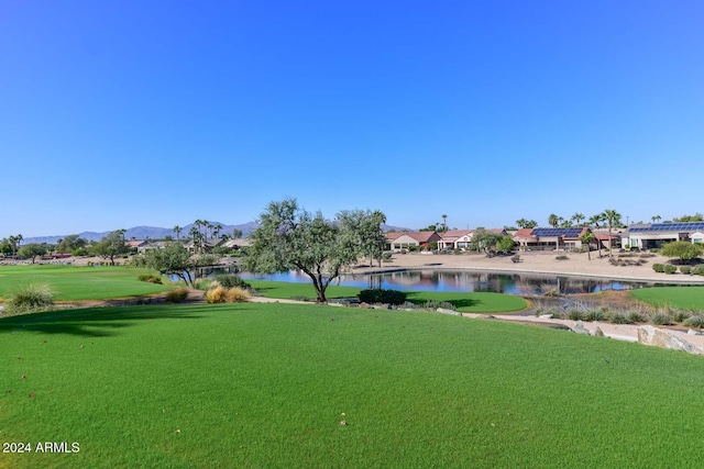 view of property's community featuring a lawn and a water and mountain view