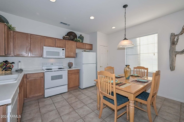 kitchen featuring sink, light tile patterned floors, pendant lighting, and white appliances