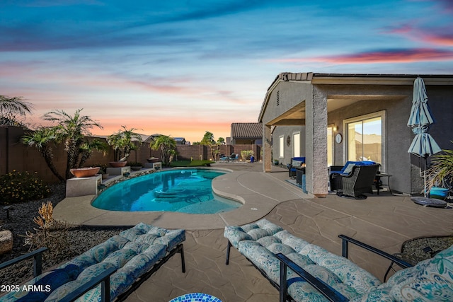 pool at dusk featuring a patio