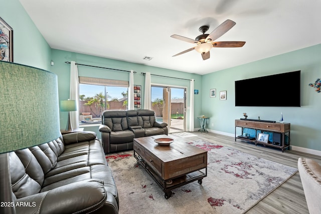 living room featuring ceiling fan and light hardwood / wood-style flooring