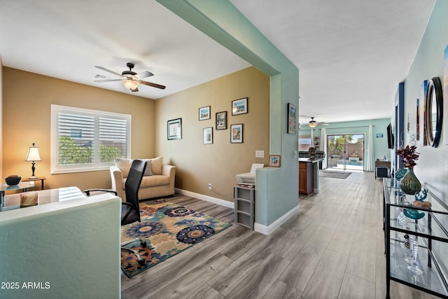 living room with light hardwood / wood-style floors and ceiling fan