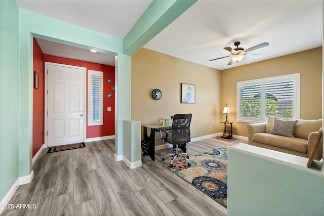 office space featuring ceiling fan, beamed ceiling, and light wood-type flooring