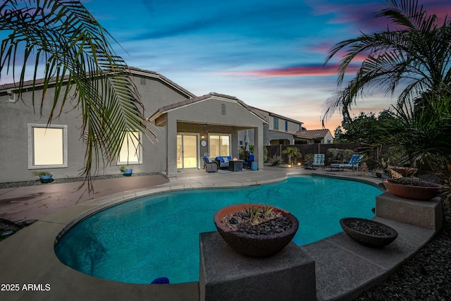 pool at dusk featuring a patio