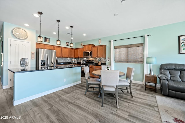 dining space featuring light wood-type flooring and sink