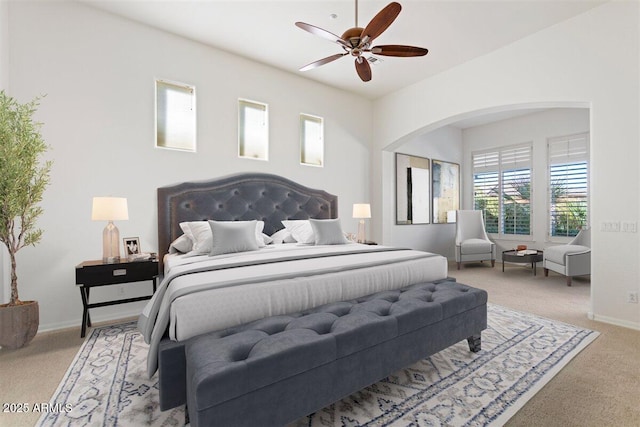 5892 E Evening Glow Dr, Scottsdale, AZ 85266 - bedroom featuring light carpet, baseboards, arched walkways, and a ceiling fan