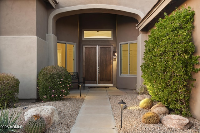 doorway to property featuring stucco siding