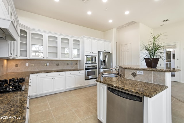 5892 E Evening Glow Dr, Scottsdale, AZ 85266 - kitchen featuring appliances with stainless steel finishes, dark stone counters, white cabinets, and glass insert cabinets