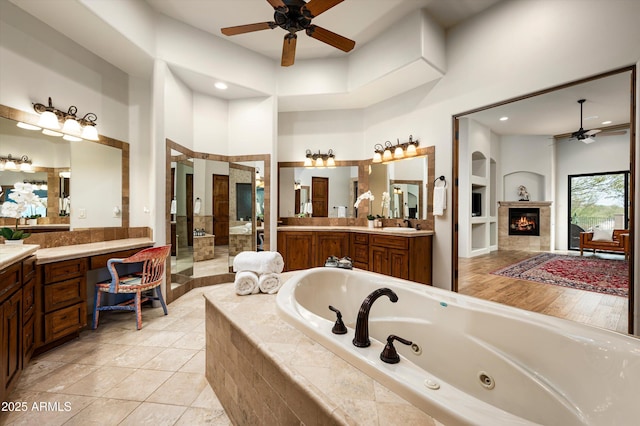 bathroom featuring a high ceiling, ceiling fan, independent shower and bath, tile patterned floors, and vanity