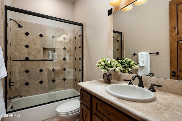 full bathroom with toilet, vanity, and bath / shower combo with glass door