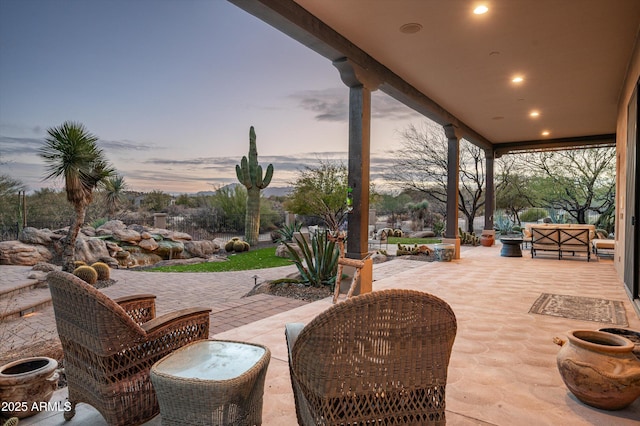 patio terrace at dusk featuring an outdoor living space