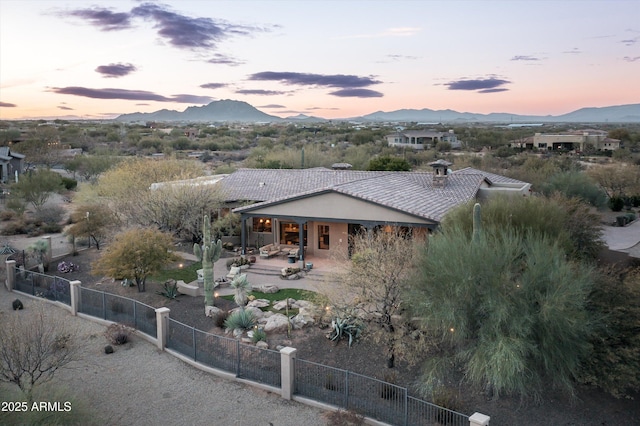 view of front of property featuring a mountain view and a patio area