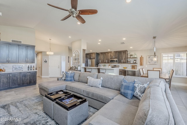 living room with recessed lighting, visible vents, a ceiling fan, vaulted ceiling, and baseboards