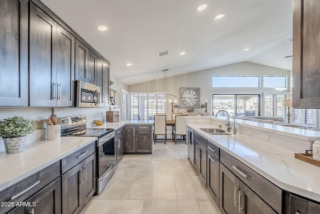 kitchen featuring light tile patterned floors, stainless steel appliances, visible vents, a sink, and light stone countertops