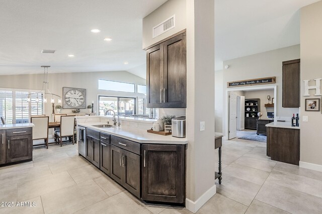 kitchen with light countertops, visible vents, a sink, and dark brown cabinetry