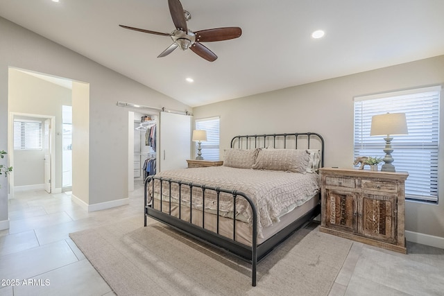 bedroom featuring lofted ceiling, a spacious closet, recessed lighting, and a barn door