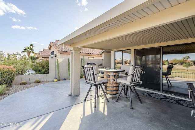 view of patio with outdoor dining area and fence