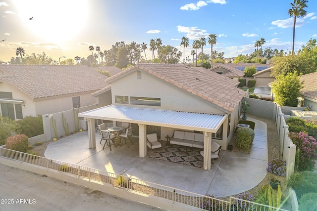 exterior space with a fenced backyard, outdoor dining space, a tiled roof, a patio area, and stucco siding