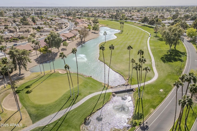 drone / aerial view with golf course view, a water view, and a residential view