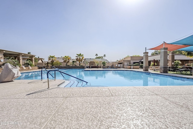 community pool with a patio area and area for grilling