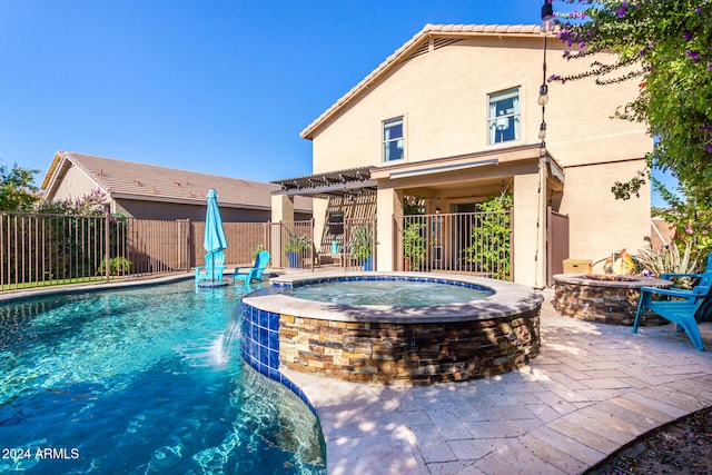 view of swimming pool with a patio, pool water feature, and an in ground hot tub