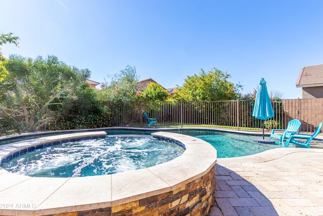 view of pool with a patio and an in ground hot tub